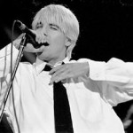 Anthony Kiedis black & white photo of him in shirt and tie singing on stage