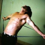 Anthony Kiedis topless against green background