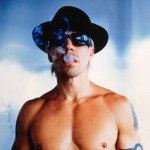 Anthony Kiedis topless wearing black hat and smoking